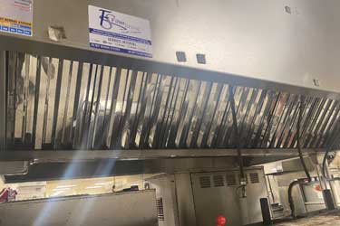 clean hood filter in commercial kitchen